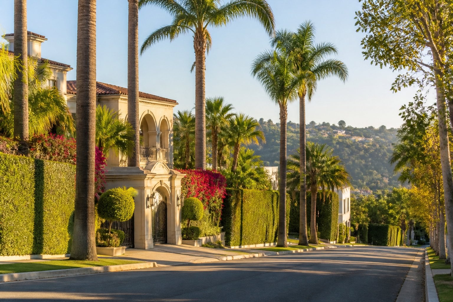 A luxurious home surrounded by manicured landscaping and palm trees on a quiet Beverly Hills residential street.