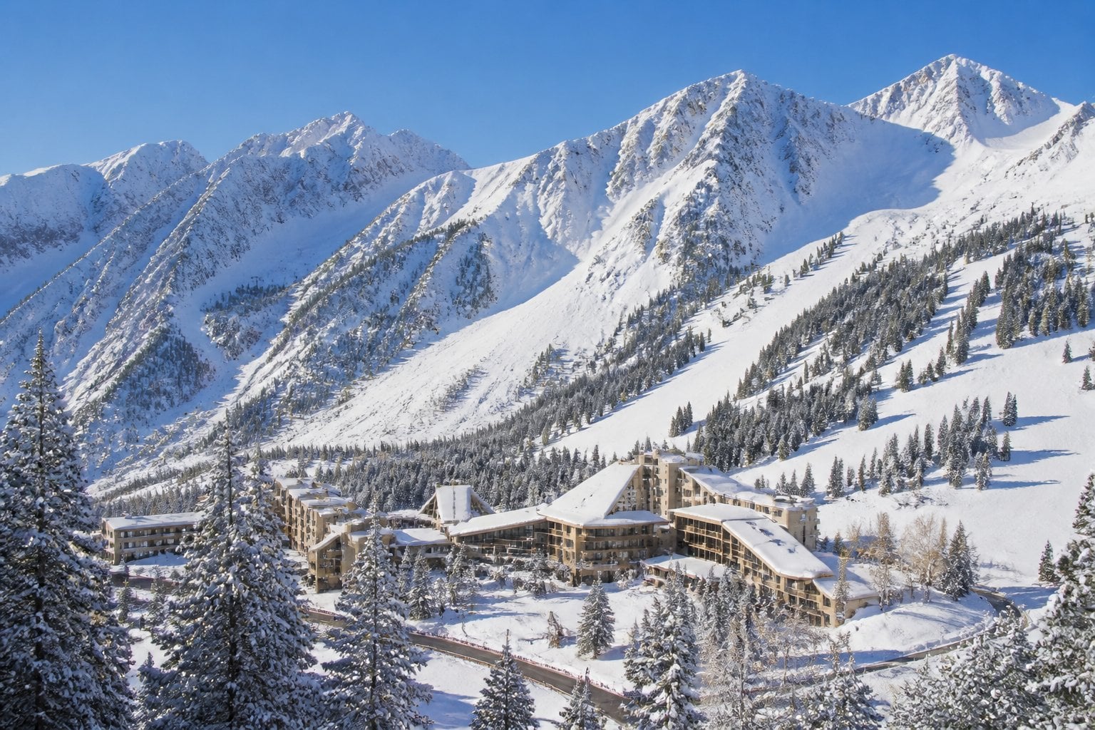 A luxurious mountain resort surrounded by snowy peaks and evergreen forests in Snowbird, Utah.