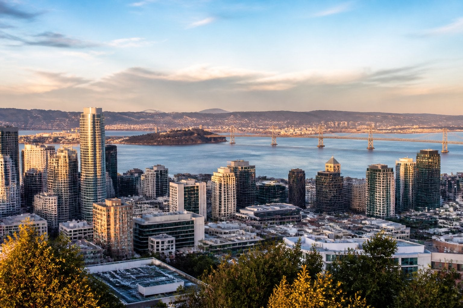 Oakland skyline and waterfront with the Bay Bridge visible in the distance.