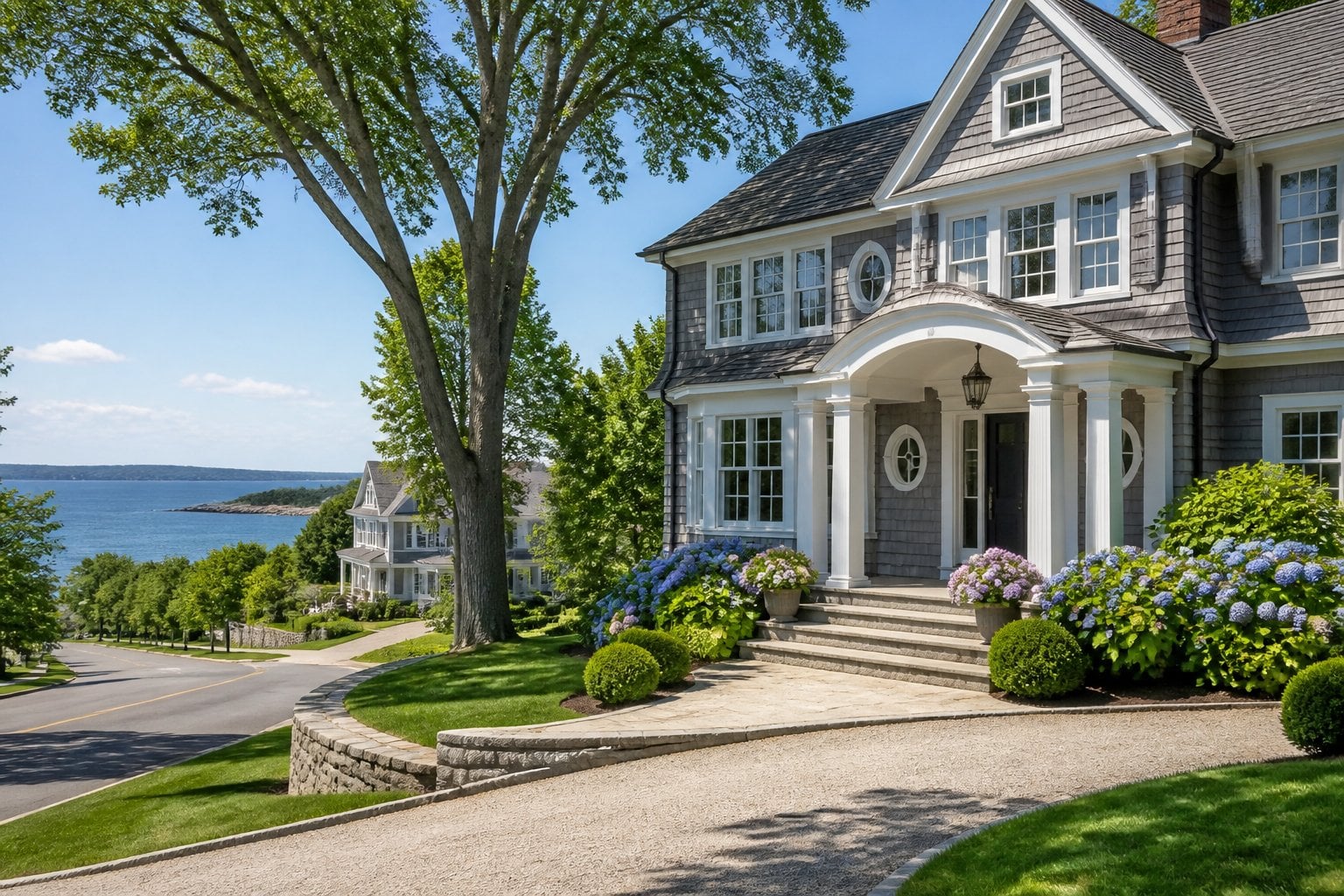 An upscale coastal neighborhood in Bridgeport, Connecticut, with a well-kept home, landscaped yard, and distant waterfront.